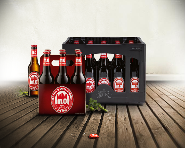 Eine Bierkiste mit sechs Flaschen und einem geöffneten Bierdeckel steht auf einem Holzboden.